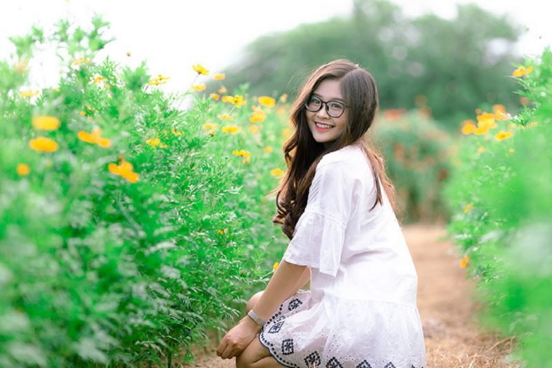 ảnh gái xinh đeo kính tạo dáng giữa vườn hoa